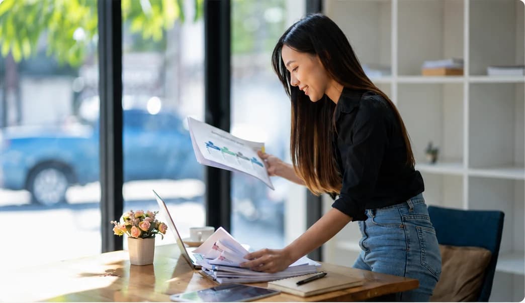 Business owner reviewing financial reports and bookkeeping documents.